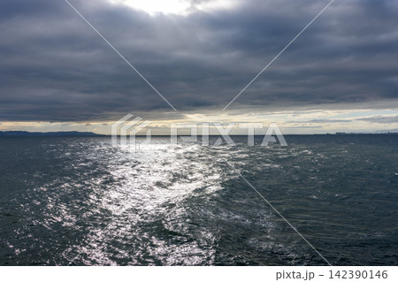A vast, dynamic seascape under an overcast sky viewed from water's edge A vast, dynamic seascape under an overcast sky viewed from water's edge 142390146