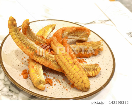 Crispy fried seasoned corn ribs served on a round plate as a delicious appetizer Crispy fried seasoned corn ribs served on a round plate as a delicious appetizer 142390353