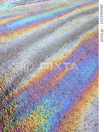 A leaked Car Oil Petrol in The Rain on a Tarmac Road Metallic Rainbow Gasoline A leaked Car Oil Petrol in The Rain on a Tarmac Road Metallic Rainbow Gasoline 142390490