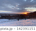 雪の積もった丘の上から見る初日の出 142391151