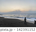 夕暮れの海を見つめる少年 142391152