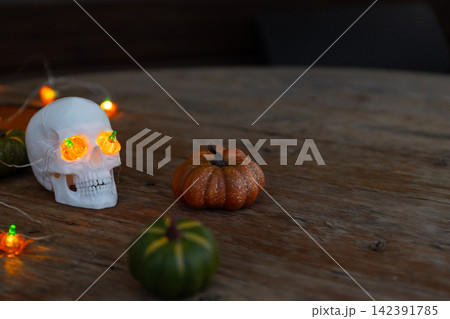Halloween Skull Prop with Glowing Eyes under Warm Orange Lights for Decorative Horror Displays Halloween Skull Prop with Glowing Eyes under Warm Orange Lights for Decorative Horror Displays 142391785