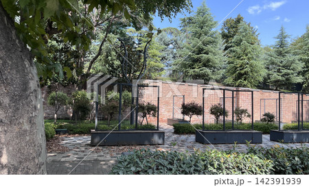 Empty garden with brick wall and metal planters 142391939