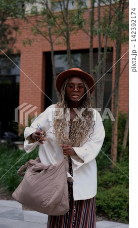 Stylish Young Woman with Long Braids Carrying Oversized Tote Bag, Urban Fashion, City Travel, Modern Lifestyle and Individuality Stylish Young Woman with Long Braids Carrying Oversized Tote Bag, Urban Fashion, City Travel, Modern Lifestyle and Individuality 142392174