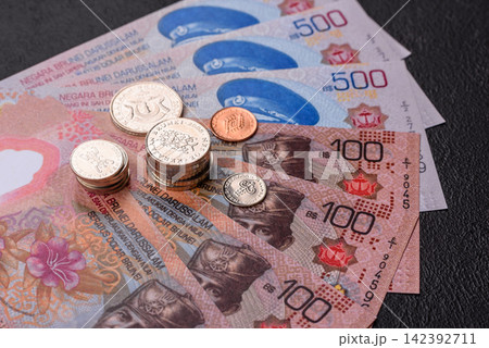 Brunei paper money, dollar banknotes and sen coins as currency for exchange or travel. Brunei money Brunei paper money, dollar banknotes and sen coins as currency for exchange or travel. Brunei money 142392711