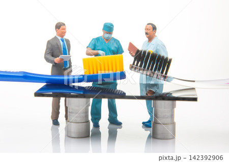 Miniature people in a dental scene discussing dental hygiene with toothbrushes and dental tools Miniature people in a dental scene discussing dental hygiene with toothbrushes and dental tools 142392906
