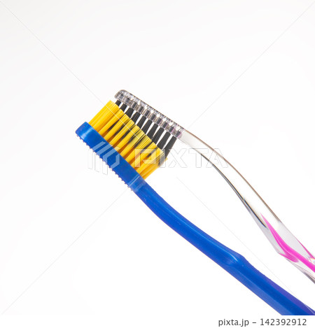 Two toothbrushes positioned to each other on a white background showing different colors and designs Two toothbrushes positioned to each other on a white background showing different colors and designs 142392912