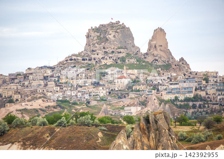 Historic rock formations and cave dwellings in Cappadocia, Turkey create a unique landscape at dusk Historic rock formations and cave dwellings in Cappadocia, Turkey create a unique landscape at dusk 142392955