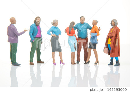 Miniature figures of diverse people standing in a group against a white background Miniature figures of diverse people standing in a group against a white background 142393000