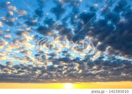 Colorful clouds in the sky at sunset over a wide landscape with changing light Colorful clouds in the sky at sunset over a wide landscape with changing light 142393010