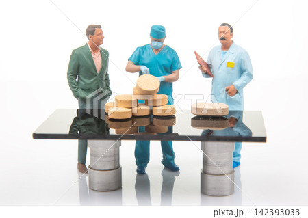 Miniature figures at a table discussing food preparation in a clean, bright kitchen setting Miniature figures at a table discussing food preparation in a clean, bright kitchen setting 142393033