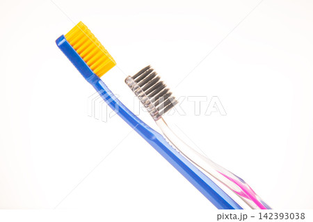 Two different toothbrushes placed side by side for comparison in a bright setting Two different toothbrushes placed side by side for comparison in a bright setting 142393038