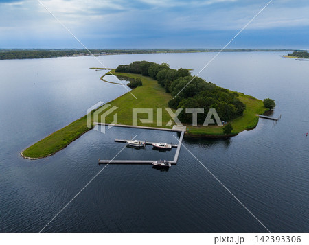 High angle wide horizontal aerial drone photograph of green island, small marina jetty, boats, and Lake Veere in Ruiterplaat, Zeeland, Netherlands on cloudy summer day High angle wide horizontal aerial drone photograph of green island, small marina jetty, boats, and Lake Veere in Ruiterplaat, Zeeland, Netherlands on cloudy summer day 142393306