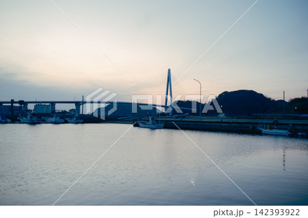 夕暮れの港に架かる斜張橋と穏やかな海 夕暮れの港に架かる斜張橋と穏やかな海 142393922
