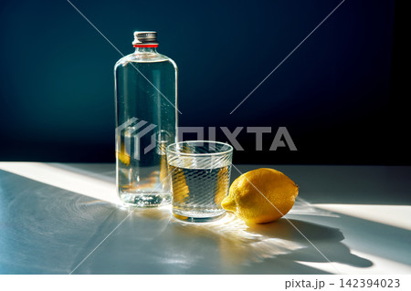 Water bottle, glass, and lemon creating refreshing beverage Water bottle, glass, and lemon creating refreshing beverage 142394023