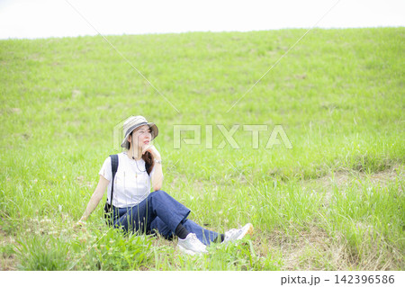 草原や河原を散歩する女性 142396586