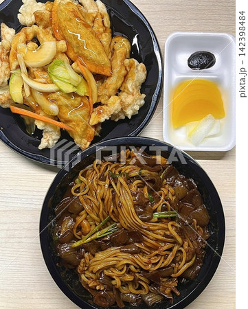 A classic Korean-Chinese combo of jajangmyeon with thick, chewy noodles coated in rich black bean sauce, served alongside crispy tangsuyuk, deep-fried pork with sweet and sour sauce. 142398484