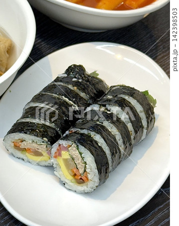 Fresh kimbap rolls filled with rice, vegetables, and savory ingredients, neatly wrapped in seaweed. Colorful, balanced, and satisfying, offering a classic Korean flavor with a clean, appetizing look. 142398503