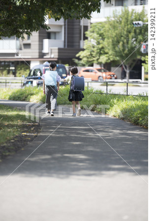 通学路を走るランドセル姿の子供たちの後ろ姿 通学路を走るランドセル姿の子供たちの後ろ姿 142399211