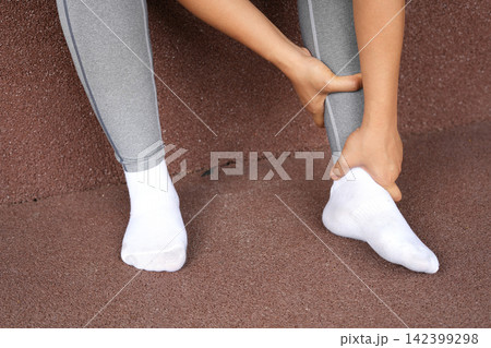 A woman with a leg ache, she is running in the park A woman with a leg ache, she is running in the park 142399298