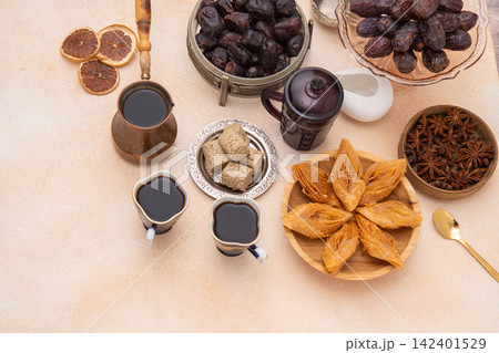 Oriental sweets and coffee on the table. Baklava, halva for dessert. Food and drink. Dates fruit Oriental sweets and coffee on the table. Baklava, halva for dessert. Food and drink. Dates fruit 142401529