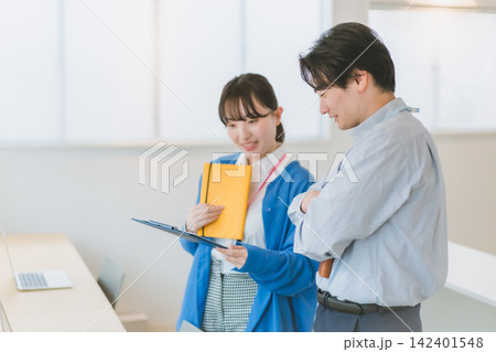 ビジネス資料を一緒に確認する女性社員のオフィスシーン ビジネス資料を一緒に確認する女性社員のオフィスシーン 142401548