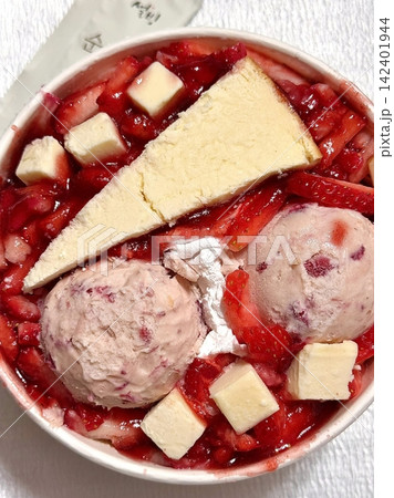 Soft and fluffy strawberry bingsu with finely shaved ice, sweet strawberry syrup, and fresh strawberry slices. A refreshing and delightful Korean dessert, perfect for a cool and fruity treat. 142401944