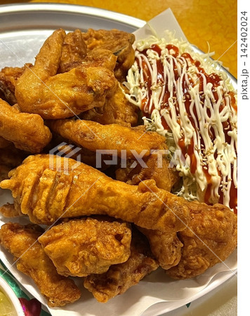 Crispy Korean fried chicken, perfectly glazed with a sweet and spicy sauce. Ideal for food photography and menus, showcasing the irresistible crunch and flavor of this beloved dish. Crispy Korean fried chicken, perfectly glazed with a sweet and spicy sauce. Ideal for food photography and menus, showcasing the irresistible crunch and flavor of this beloved dish. 142402024