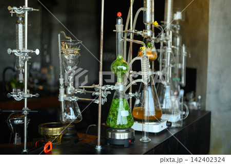 Herbal Essential Oil Distillation Laboratory Setup with Glass Flasks and Plant Extracts Herbal Essential Oil Distillation Laboratory Setup with Glass Flasks and Plant Extracts 142402324