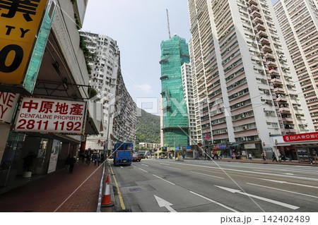 City street with tall buildings and busy shops in hong kong City street with tall buildings and busy shops in hong kong 142402489
