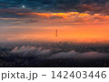Sunset sky with vibrant orange and dark clouds over city 142403446