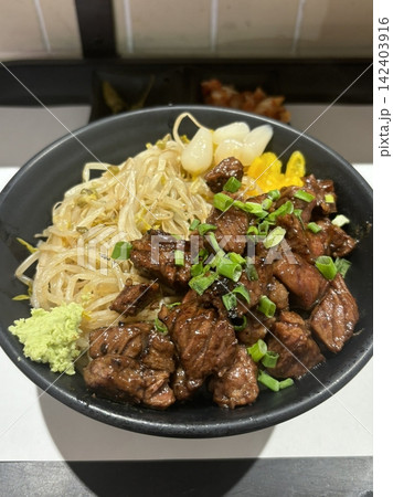 Juicy sliced steak served over warm rice in a hearty bowl, offering tender texture and rich savory flavor. Simple, satisfying, and visually appealing, perfect for modern comfort food visuals. 142403916