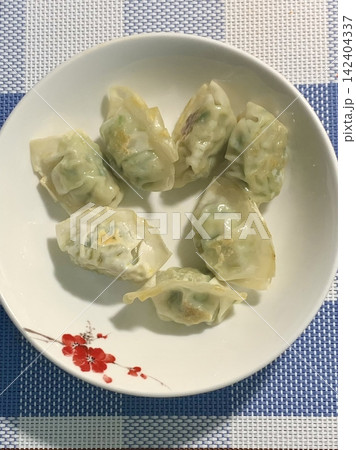 Korean dumplings filled with a mix of savory ingredients like ground meat, tofu, and vegetables. Mandu can be steamed, boiled, or pan-fried, making it a versatile and delicious snack or meal. 142404337