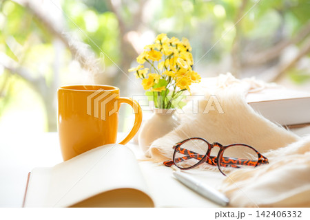 Notebook with life goals for personal growth and future planning with yellow cup coffee in warm sunshine Notebook with life goals for personal growth and future planning with yellow cup coffee in warm sunshine 142406332