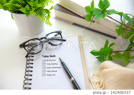 Notebook with life goals checklist on a bright workspace for personal growth and future planning with coffee. Notebook with life goals checklist on a bright workspace for personal growth and future planning with coffee. 142406337