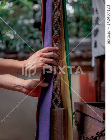 神社でお賽銭をした後にお祈りのために鐘を鳴らす手 神社でお賽銭をした後にお祈りのために鐘を鳴らす手 142407123