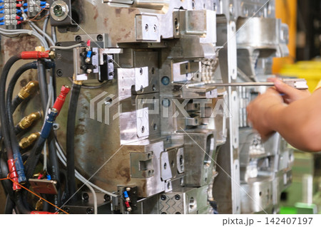 The workers are operating machinery in the factory. The workers are operating machinery in the factory. 142407197