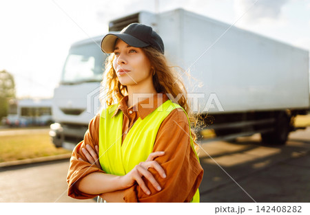 Woman Driver standing near truck. Transport industry theme. Logistic shipping. Woman Driver standing near truck. Transport industry theme. Logistic shipping. 142408282