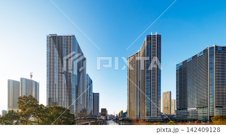 青空に向かってそびえ立つ高層タワーマンションと街並み 142409128