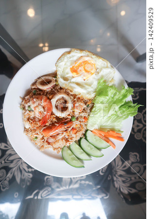 fried rice or stir-fried rice with shrimp , squid and fried egg or sunny side up egg fried rice or stir-fried rice with shrimp , squid and fried egg or sunny side up egg 142409529