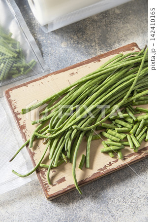 Vacuum sealed fresh green beans in packaging on a light grey background, healthy eating, zero waste, meal prep concept. Copy space. Vacuum sealed fresh green beans in packaging on a light grey background, healthy eating, zero waste, meal prep concept. Copy space. 142410165
