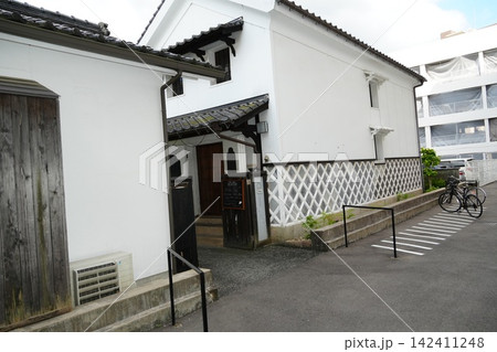 昼の商店街に佇む白壁店舗(静かな平日の街ロケ) 昼の商店街に佇む白壁店舗(静かな平日の街ロケ) 142411248