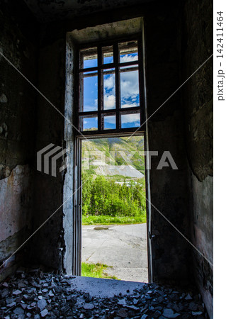 Abandoned Soviet-era Palace of Culture in the former mining settlement of Kukisvumchorr near Kirovsk, Murmansk Region, Russia. The decaying cultural building stands beneath the Khibiny Mountains, surr Abandoned Soviet-era Palace of Culture in the former mining settlement of Kukisvumchorr near Kirovsk, Murmansk Region, Russia. The decaying cultural building stands beneath the Khibiny Mountains, surr 142411464