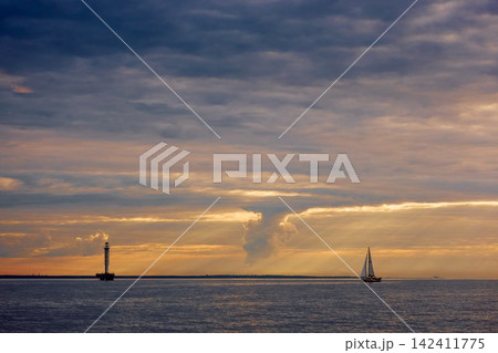Yachtsmen are sitting amicably on board the boat at incredible sunset, sailing boat is in sailing regatta in the Gulf of Finland, magic splashing water, teamwork, Russia, St.Petersburg 142411775