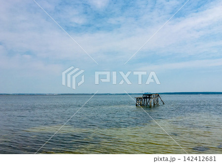 Netishyn Reservoir summer landscapes with wooden pier, green reeds, and beach rest, Ukraine 142412681