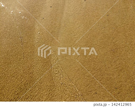 Wet sand texture on a sea beach with clear water wave edge Wet sand texture on a sea beach with clear water wave edge 142412965