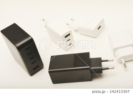 Black and white power supplies for mobile devices. Powerful power supplies on a white background. Charging devices for gadgets. 142413307