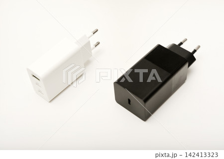 Black and white power supplies for mobile devices. Powerful power supplies on a white background. Charging devices for gadgets. 142413323