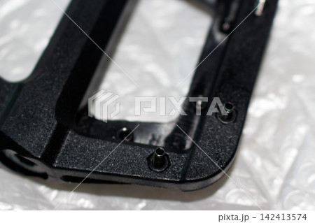 Close-up macro detail of sharp metal traction pins installed on a durable black nylon bicycle pedal, brand new cycling hardware components designed for professional mountain bike riding Close-up macro detail of sharp metal traction pins installed on a durable black nylon bicycle pedal, brand new cycling hardware components designed for professional mountain bike riding 142413574