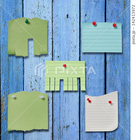 Various paper stickers and tear-off ads pinned to an old blue wooden board. Various paper stickers and tear-off ads pinned to an old blue wooden board. 142413972